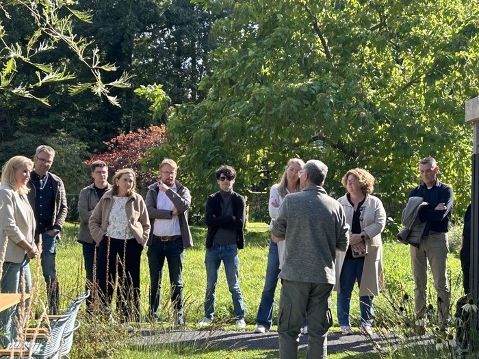 Raadsleden luisteren tijdens de rondleiding in de Tuinen Mien Ruys